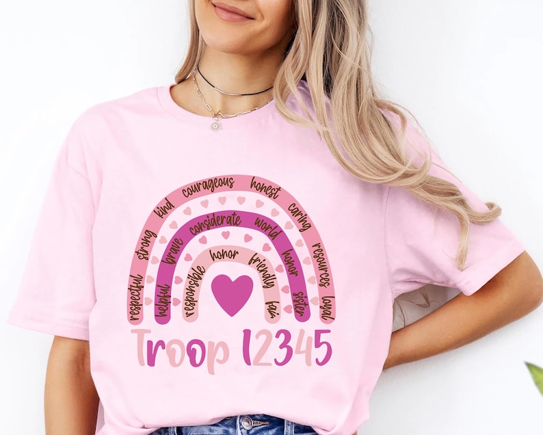 a woman wearing a pink crop top with a rainbow on it