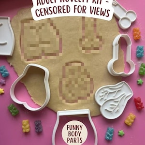 Pode incluir: Um conjunto de cortadores de biscoitos de plástico branco com formas variadas, incluindo formas anatómicas, dispostos sobre massa estendida. O texto ADULT NOVELTY KIT - CENSORED FOR VIEWS e FUNNY BODY PARTS é visível. Gomas estão espalhadas.