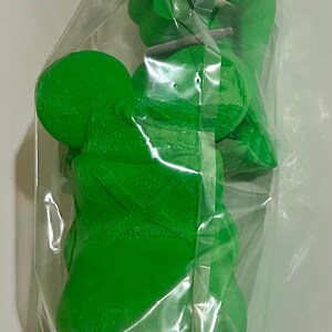 Peut inclure: Des figurines de jouets en plastique vert vif sont emball&eacute;es dans un sac en plastique transparent. Les figurines ont une forme arrondie avec des surfaces textur&eacute;es. Le sac est scell&eacute; avec du ruban adh&eacute;sif transparent. Les jouets semblent neufs.