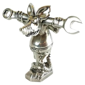 May include: A silver-coloured figurine of a rat holding a spanner and a socket wrench. The rat has large ears, a long nose, and a belt around its waist. The figurine stands on a rectangular base.