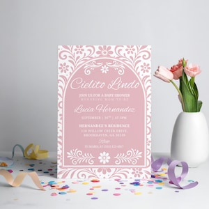 May include: A baby shower invitation with the text "Cielito Lindo" in a decorative font. The invitation is pink with white floral accents and includes details about the event, such as the date, time, and location.
