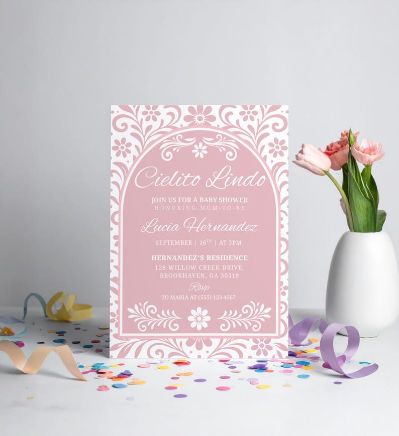 May include: A baby shower invitation with the text "Cielito Lindo" in a decorative font. The invitation is pink with white floral accents and includes details about the event, such as the date, time, and location.