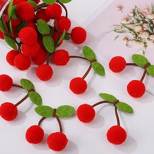 May include: Red felt cherry ornaments with green felt leaves. The cherries are attached to brown felt stems.
