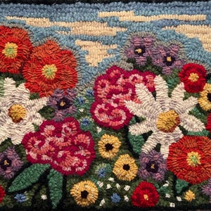 May include: Hand-hooked rug featuring a vibrant floral design. The rug showcases a variety of colorful flowers, including red, white, and purple blooms, set against a blue sky background with fluffy white clouds. The rug is framed with a black border.