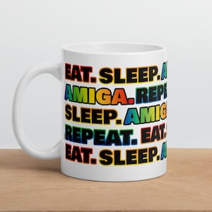 May include: White ceramic mug with a rainbow-colored design that reads "EAT. SLEEP. AMIGA. REPEAT. SLEEP. AMIGA. REPEAT. EAT. SLEEP."
