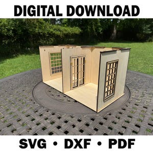 May include: A small wooden dollhouse with three rooms, including windows and a door. The text "DIGITAL DOWNLOAD" is at the top, and "SVG • DXF • PDF" is at the bottom. The dollhouse is on a dark grey table with a green background.