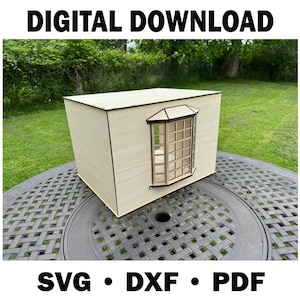 Op de afbeelding: Een lichtgekleurde houten doos met een erkerontwerp. De doos staat buiten op een ronde tafel met een patroon, met groen gras en bomen op de achtergrond. De tekst "DIGITAL DOWNLOAD" staat bovenaan en "SVG • DXF • PDF" onderaan.