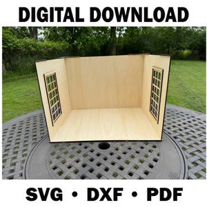 Puede incluir: Una habitación de casa de muñecas de madera con dos recortes de ventanas. La habitación es de madera de color claro con ribetes marrón oscuro. El texto "DESCARGA DIGITAL" y "SVG • DXF • PDF" están en la parte superior e inferior de la imagen.