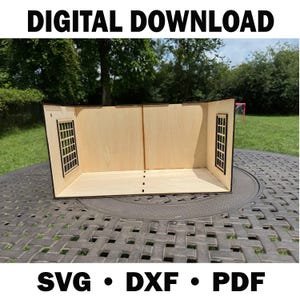 Puede incluir: Una casa de muñecas de madera con dos ventanas y una base rectangular. La casa de muñecas está hecha de madera de color claro y tiene un diseño sencillo. El texto "DIGITAL DOWNLOAD" está en la parte superior y "SVG • DXF • PDF" en la inferior.