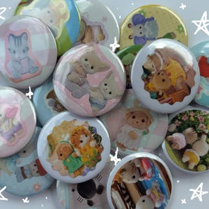 May include: A collection of 12 colorful round buttons featuring various cartoon animal characters. The buttons are decorated with pink, blue, green, and yellow colors. The characters include a cat, a dog, a rabbit, a bear, and a squirrel. The buttons are perfect for adding a touch of whimsy to any project.