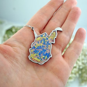 以下が含まれることがあります： 青い花と黄色い花が押し花された、ウェストバージニア州の輪郭のペンダントが付いたシルバーネックレス