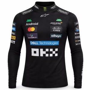 Könnte beinhalten: Schwarzes Langarm-Rennshirt mit Stehkragen. Das Shirt zeigt mehrere Sponsorenlogos, darunter "Hilton", "Android", "McLaren", "Dell Technologies" und "OKX". Oben ist ein grünes Monster Energy-Logo zu sehen.