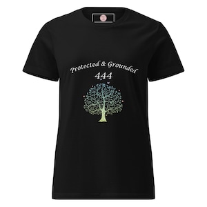 Könnte beinhalten: Schwarzes T-Shirt mit dem Schriftzug "Protected & Grounded 444" in weißer Schrift. Ein farbenfrohes Baumdesign mit Blättern und kleinen Vögeln ist unter dem Text zentriert. Das T-Shirt hat einen Rundhalsausschnitt und kurze Ärmel.