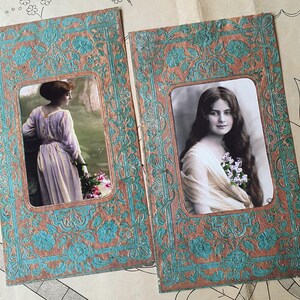 Op de afbeelding: Twee vintage ansichtkaarten met sierlijke lijsten met afbeeldingen van vrouwen. De lijsten zijn versierd met een turquoise en bruin bloemenpatroon. De vrouwen zijn gekleed in vintage kleding en hebben lang haar.