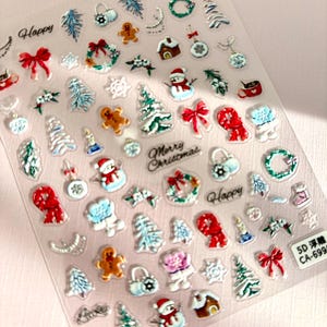 May include: Clear sheet of Christmas-themed stickers. Designs include snowmen, gingerbread men, Christmas trees, bows, wreaths, and ornaments. Text includes "Happy", "Lucky", and "Merry Christmas".