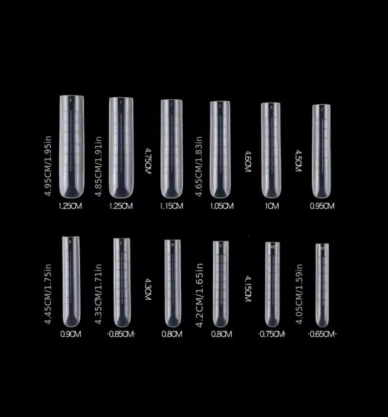 May include: A set of 12 clear plastic nail tips in various sizes. The tips are arranged in two rows, with the largest tips at the top and the smallest tips at the bottom. The tips are labeled with their size in centimeters and inches.