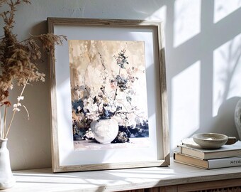 May include: A framed art print featuring a still life of white flowers in a white vase. The artwork has a soft, painterly style with neutral tones and a light wooden frame. The print is displayed on a white surface.