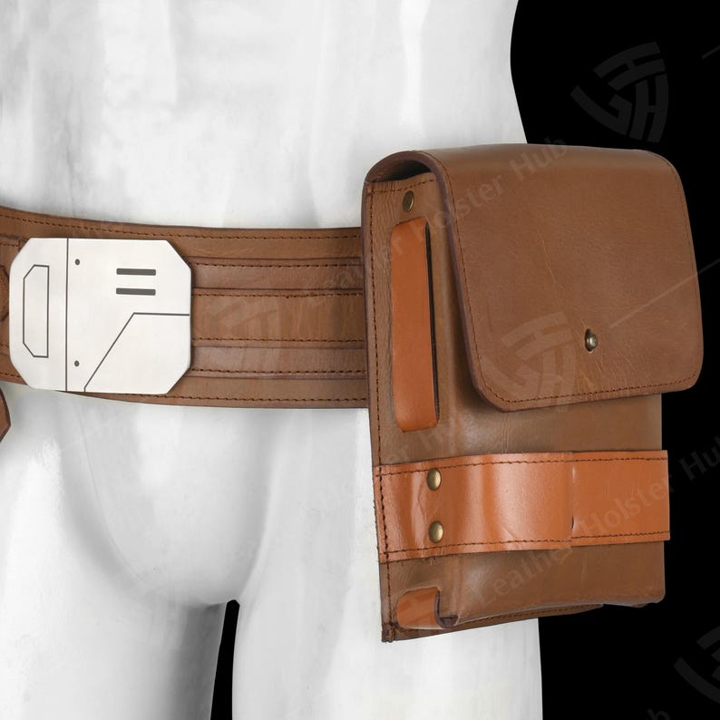 Puede incluir: Cintur&oacute;n de cuero marr&oacute;n con una bolsa rectangular y una hebilla plateada. El cintur&oacute;n tiene un acento marr&oacute;n claro en la bolsa y est&aacute; asegurado con remaches. La hebilla tiene un dise&ntilde;o geom&eacute;trico.