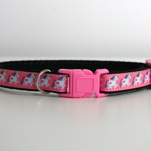 May include: Pink and black cat collar with a pink plastic buckle and a white unicorn print.