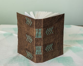 Small brown notebook with arrow stitching embellishments