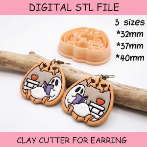 Op de afbeelding: Een digitaal STL-bestand voor een kleisnijder voor oorbellen, in de vorm van een pompoen met een geest die een boek leest en een appel. De tekst luidt DIGITAL STL FILE, 3 sizes, 32mm, 37mm, 40mm en CLAY CUTTER FOR EARRING.