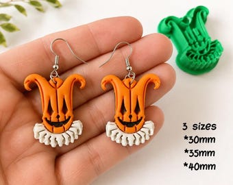 May include: A pair of orange and white jester-shaped earrings with silver-toned hooks, accompanied by a green plastic clay cutter. Text reads: DIGITAL STL FILE, 3 sizes, 30mm, 35mm, 40mm, CLAY CUTTER FOR EARRING.