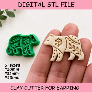 May include: A green bear-shaped clay cutter and a beige clay bear cutout with snowflake and leaf patterns. Text reads: DIGITAL STL FILE, 3 sizes *30mm *35mm *40mm, CLAY CUTTER FOR EARRING. The bear design features intricate embossed details.