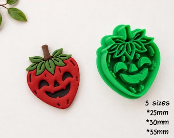 May include: A digital STL file for a clay cutter for earrings, featuring a strawberry-shaped design with a jack-o'-lantern face. The set includes a red strawberry-shaped clay piece and a green plastic cutter, available in 25mm, 30mm, and 35mm sizes.
