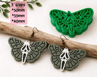 May include: A green butterfly-shaped clay cutter and two matching earrings featuring a white ghost mask design on green wings. The text reads DIGITAL STL FILE, 3 sizes, 30mm, 35mm, 40mm, and CLAY CUTTER FOR EARRING. The earrings have bronze-toned hooks.