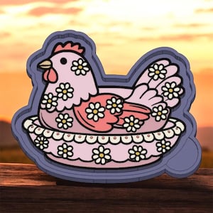 May include: A pink hen cookie cutter with daisy flower accents. The hen is sitting in a nest, and the entire design is outlined in a darker purple. The background is a blurred sunset.