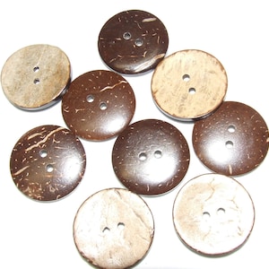 May include: A selection of ten round coconut shell buttons. The buttons range in colour from light tan to dark brown, each with two sewing holes. The natural texture and grain of the coconut shell are visible on each button.