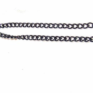 May include: A black chain necklace with a curb link design. The necklace is displayed against a white background. The chain is made of metal and has a shiny finish. The links are uniform in size and shape.