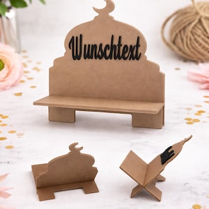 Könnte beinhalten: Drei braune Kartonzuschnitte, darunter ein bankförmiges Stück mit dem Wort "Wunschtext" und einem Halbmond, sowie zwei kleinere Teile. Die Teile liegen auf einer weißen Oberfläche mit goldenem Konfetti und rosa Blumen.