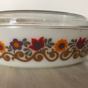 May include: White oval casserole dish with a lid. The dish has a floral pattern in shades of orange, yellow, purple, and brown.
