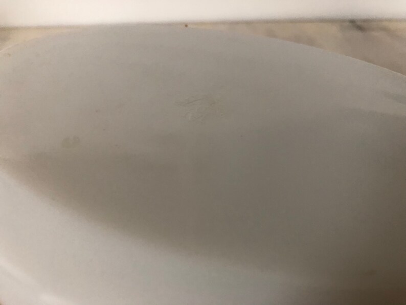 May include: White ceramic bowl with a smooth, glossy finish. The bowl has a slight indentation on the bottom.