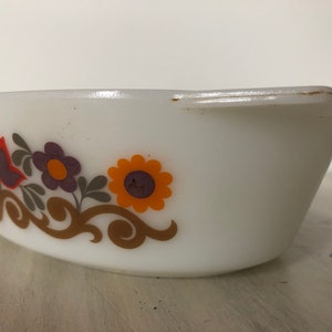 May include: White oval baking dish with a floral design in shades of orange, purple, and brown. The design features stylized flowers and leaves.