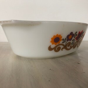 May include: White oval baking dish with a floral design in shades of orange, brown, purple, and green. The design features stylized flowers and swirls.
