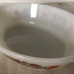 May include: White oval baking dish with a floral pattern in shades of brown, orange, and yellow.