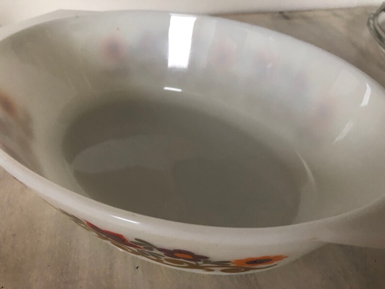May include: White oval baking dish with a floral pattern in shades of brown, orange, and yellow.