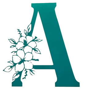May include: Teal letter A with a white floral design. The letter is a decorative accent for a home or office.
