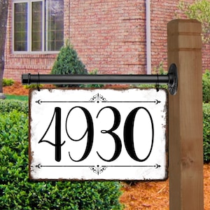 May include: White metal house number sign with black lettering and decorative flourishes. The sign reads "4930".