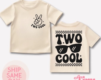 May include: Two beige t-shirts with black text and graphics. The front of the shirt says "Two Cool" with a peace sign. The back of the shirt says "Two Cool" with sunglasses.