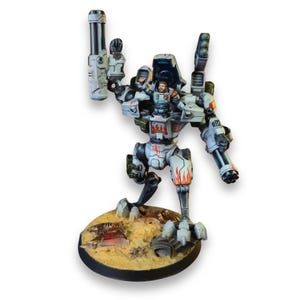 May include: A painted miniature robot mech suit with a pilot figure in the cockpit. The mech is light gray with orange flame decals, featuring a large cannon on the right arm, a multi-barreled gun on the left, and a missile pod on the back.