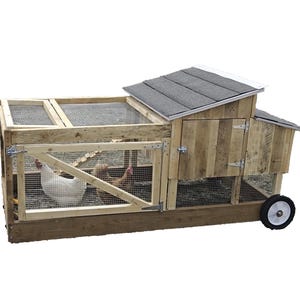 May include: A wooden chicken coop with a black shingled roof, a hinged door, and a wheeled base. Two chickens are visible inside the coop.