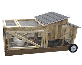 May include: A wooden chicken coop with a black shingled roof, a hinged door, and a wheeled base. Two chickens are visible inside the coop.