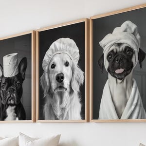 May include: Set of three framed black and white dog portraits. One features a French Bulldog with a toilet paper roll on its head, another a Golden Retriever in a chef's hat, and the last a Pug in a towel and robe.