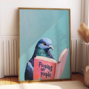 Può includere: Stampa artistica incorniciata raffigurante un piccione colorato che legge un libro con il testo "Pooping on people". Il piccione ha piume blu, verdi e viola, su uno sfondo azzurro.