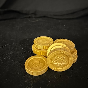 Könnte beinhalten: Ein Stapel aus sechs goldfarbenen, runden Holzmarken mit einem fünfzackigen Sternmuster auf jeder. Die Marken sind in einem Stapel angeordnet, wobei der Stern nach oben zeigt.