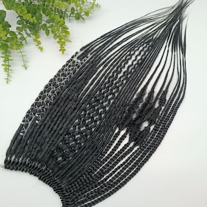 May include: A collection of black synthetic hair extensions, showcasing a variety of braiding techniques. The extensions include straight, twisted, and patterned braids, providing diverse styling options. The hair is neatly arranged, highlighting the different textures and designs.