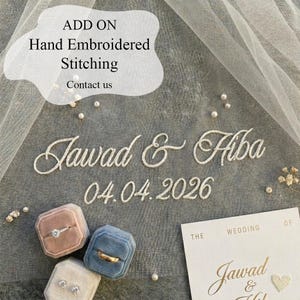 May include: An image featuring hand-embroidered text that reads "Jawad & Hiba" and the date "04.04.2026". The image also includes ring boxes in pink, blue, and cream, along with a wedding invitation. The text "ADD ON Hand Embroidered Stitching Contact us" is also visible.